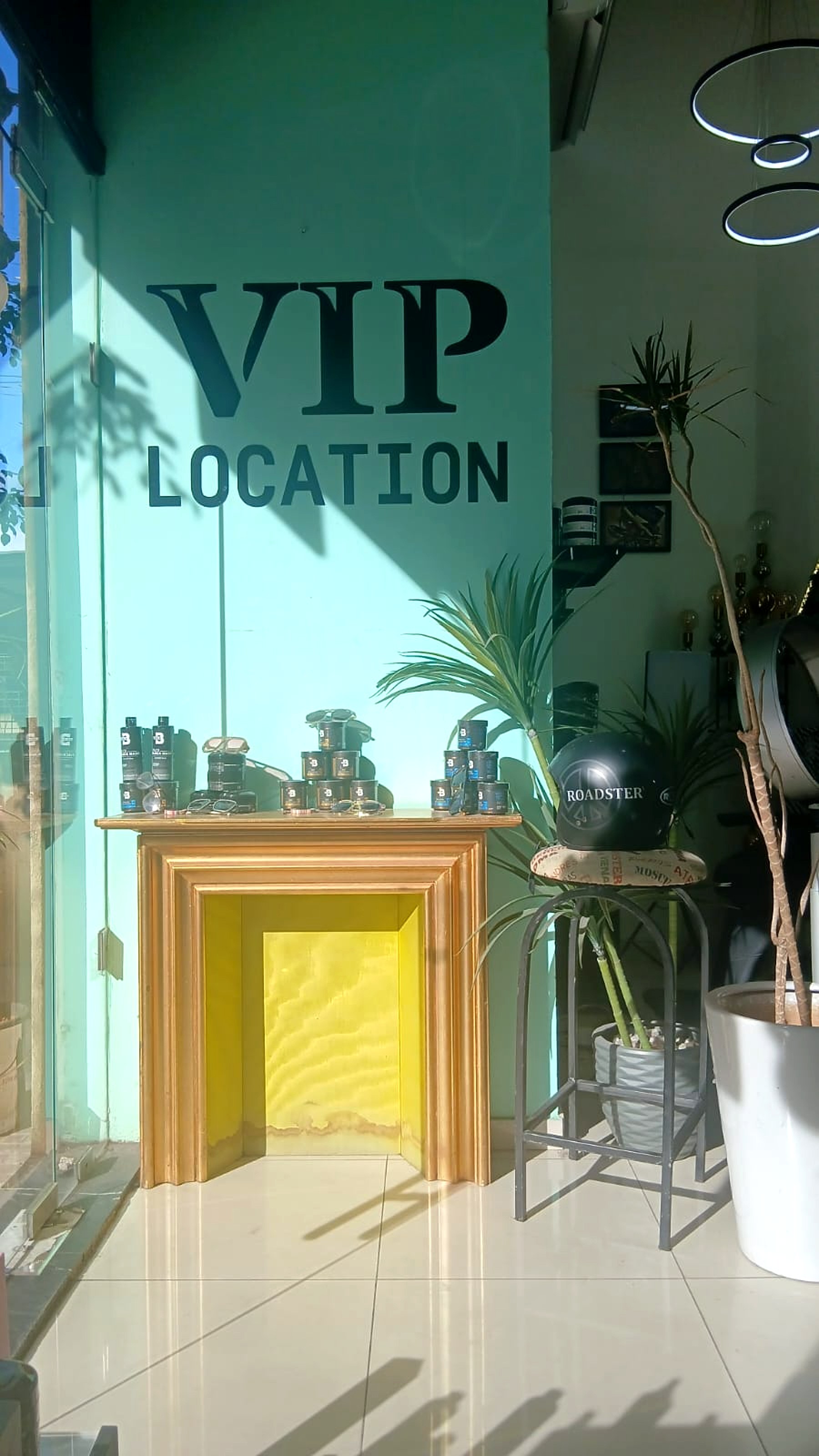 The VIP Location wall at Barber Shop Manolli: mint paint, gilded mantel and grooming products